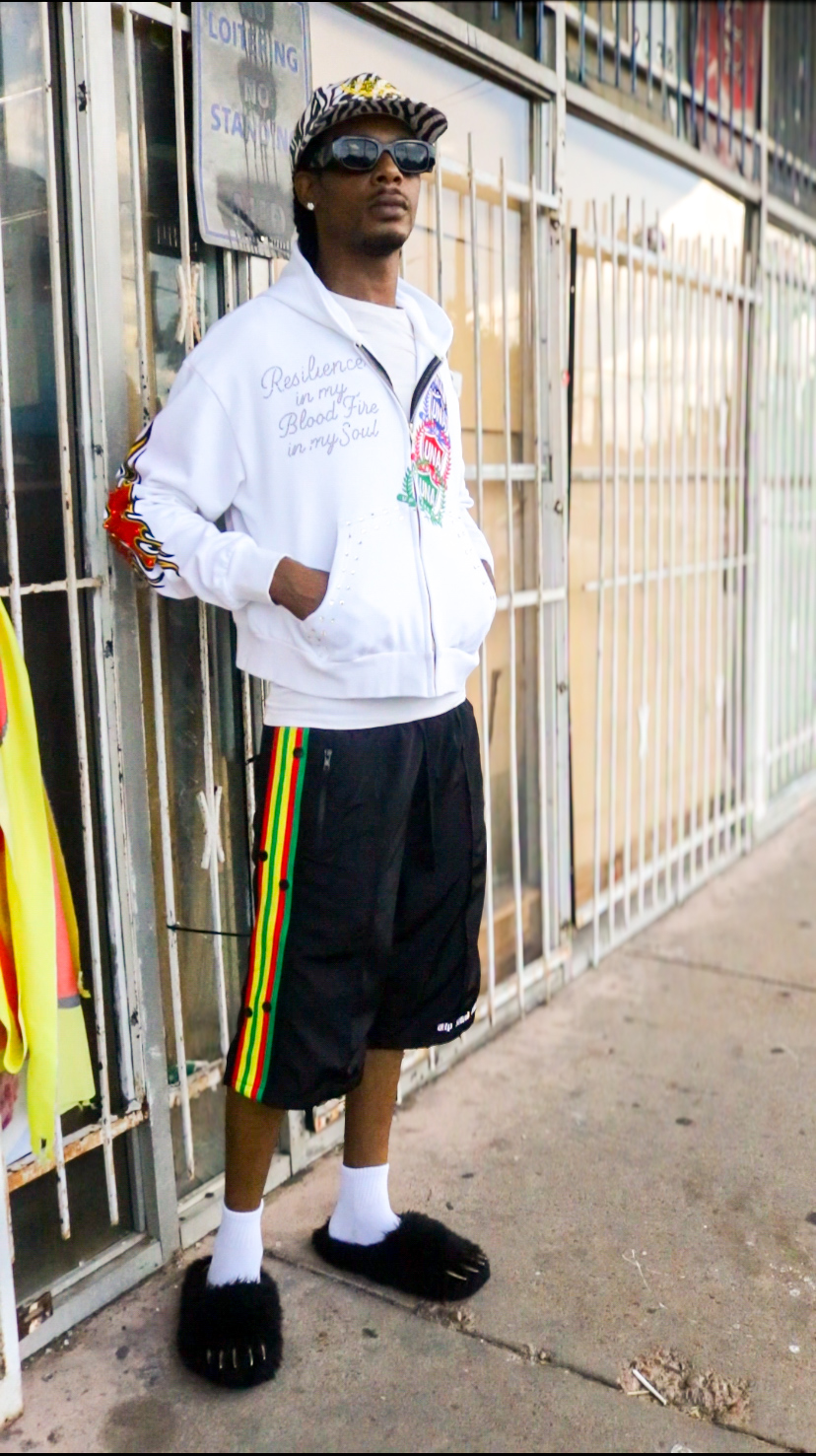 Model leaning against a fence in the white UNA hoodie
