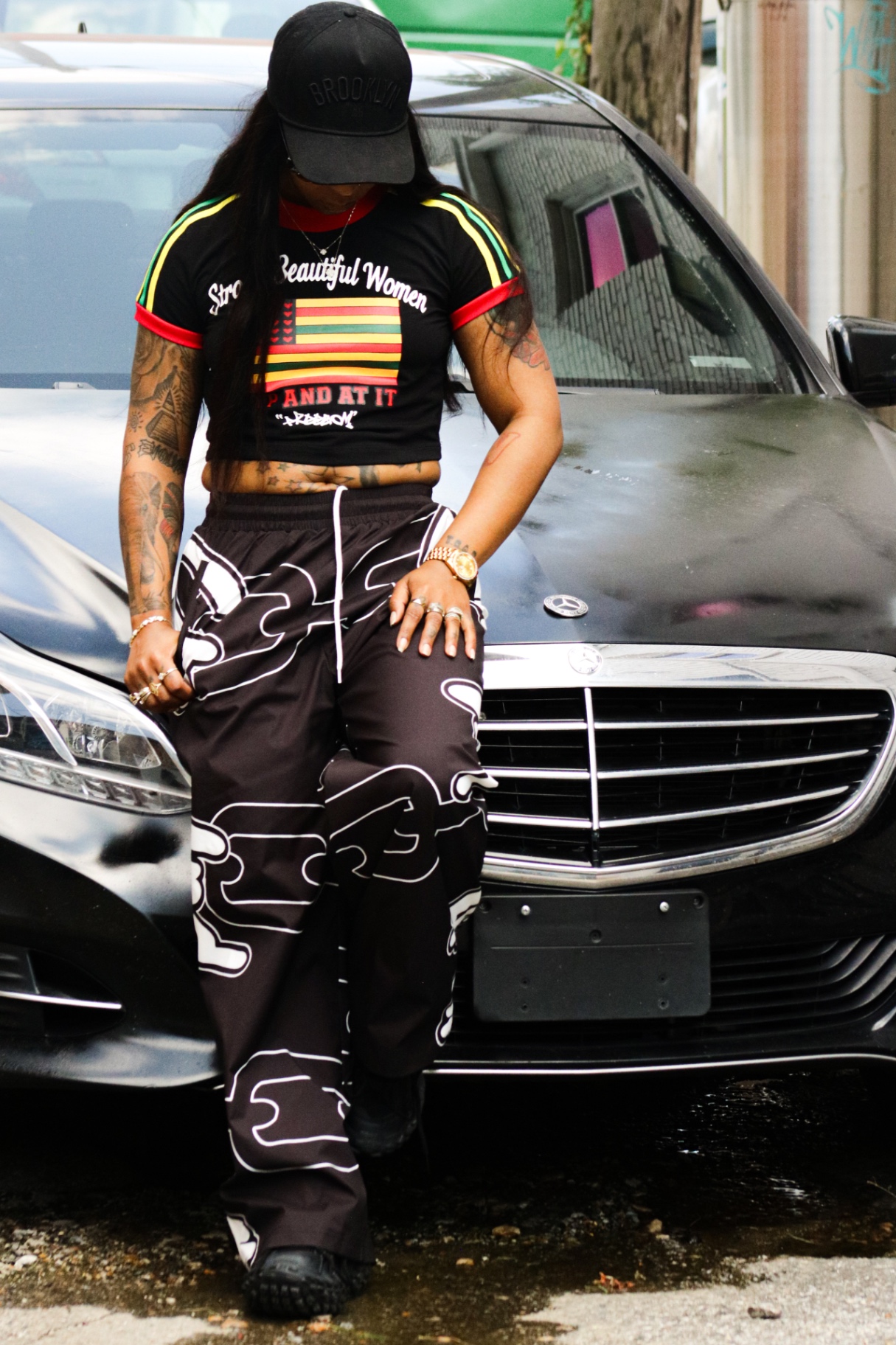 Model in the Freedom crop tee leaning on a car