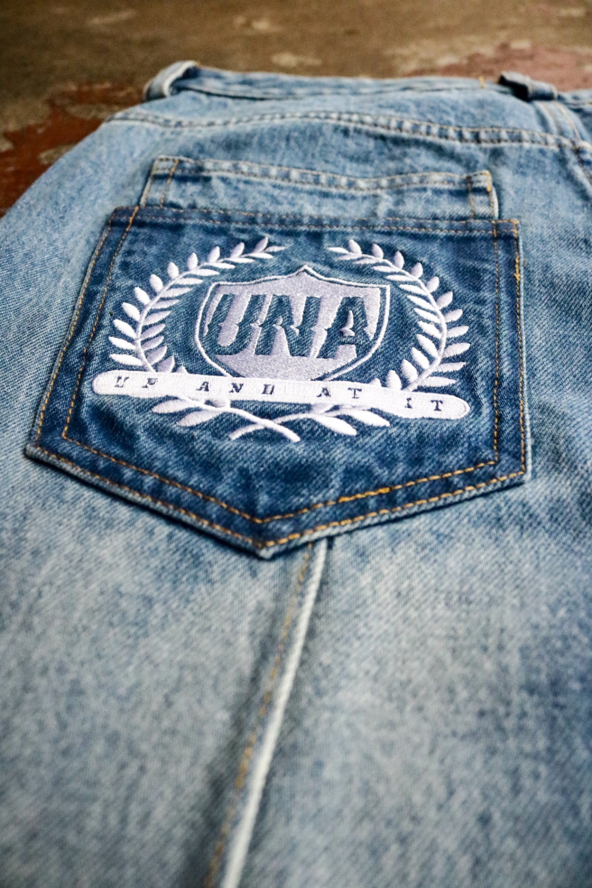 Embroidered UNA laurel crest denim pocket